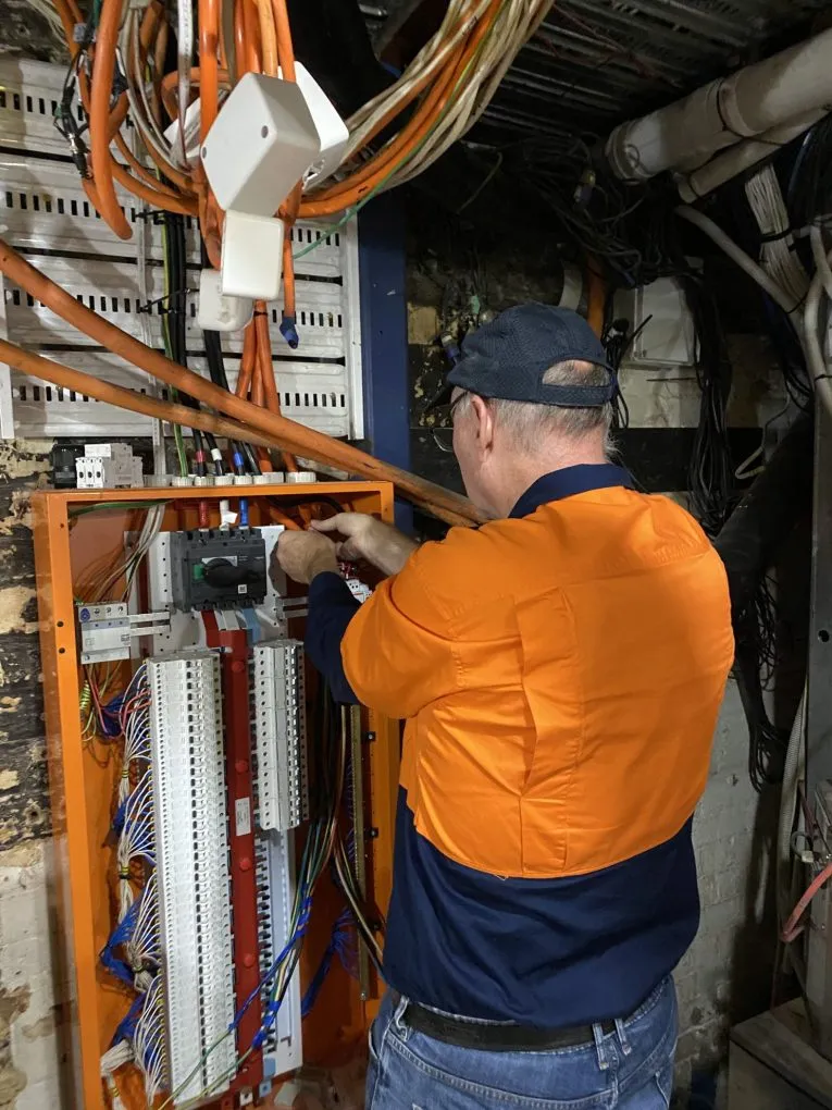 A KTM electrician servicing a commercial distribution board